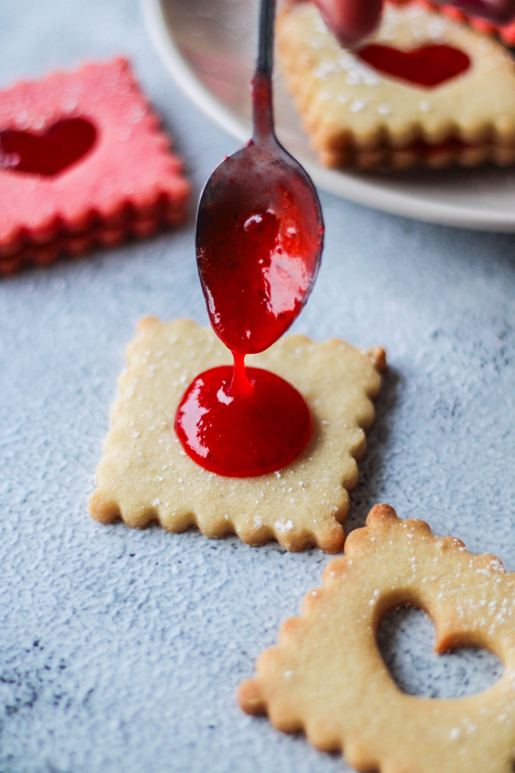 Foodstyling-Beispiel, be dem ein Keks wird mit Erdbeermarmelade gefüllt wird