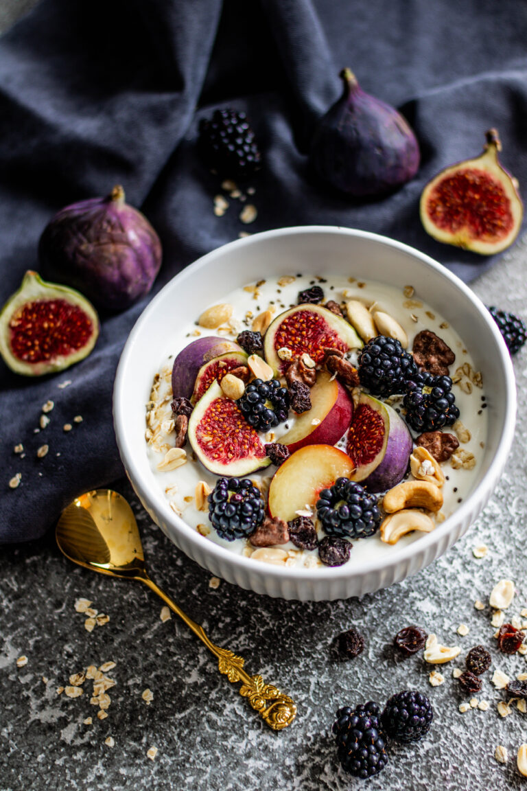 Frühstücksbowl mit frischen Feigen, Nektarinen, Brombeeren und Nüssen